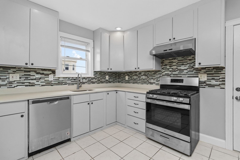 66 Stanley Street Boston, MA 02125 - Photo 34 of 42 a kitchen with granite countertop white cabinets and white appliances