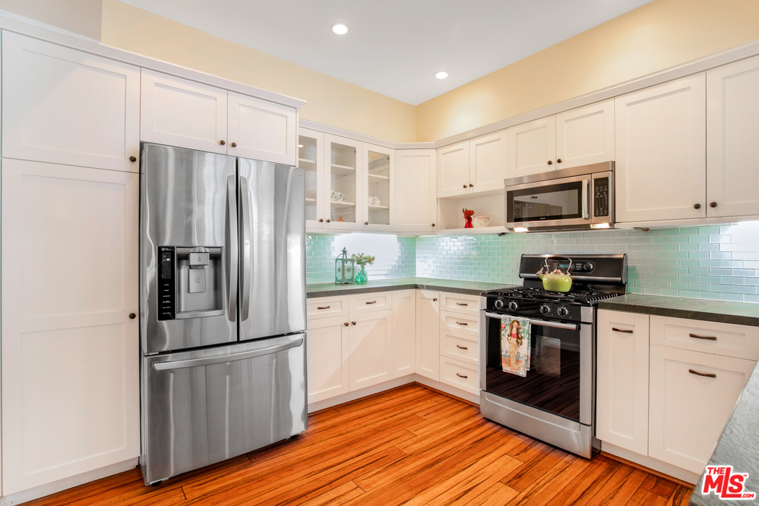 8180 Manitoba Street, Unit 124 Playa del Rey, CA 90293 - Photo 11 of 30 a kitchen with granite countertop a refrigerator stove and microwave