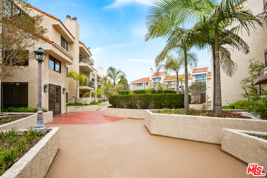 8180 Manitoba Street, Unit 124 Playa del Rey, CA 90293 - Photo 25 of 30 a view of a house with a swimming pool and a patio
