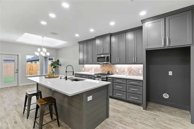 a kitchen with stainless steel appliances granite countertop a sink a stove and a refrigerator