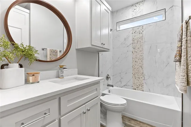 a bathroom with a sink a toilet and a mirror