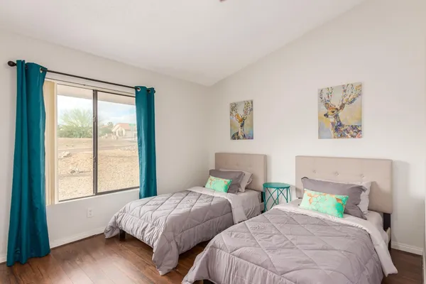 a bedroom with two beds and a large window