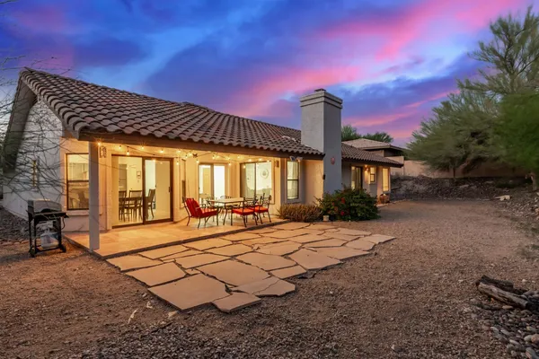 a view of a house with backyard and sitting area