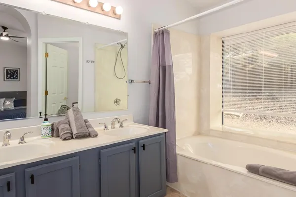 a bathroom with a tub sink and mirror