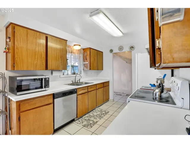 a kitchen with stainless steel appliances a sink stove and refrigerator