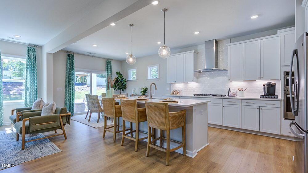 151 Rivulet Court Cary, NC 27519 - Photo 15 of 37 a kitchen with granite countertop a dining table chairs and white cabinets