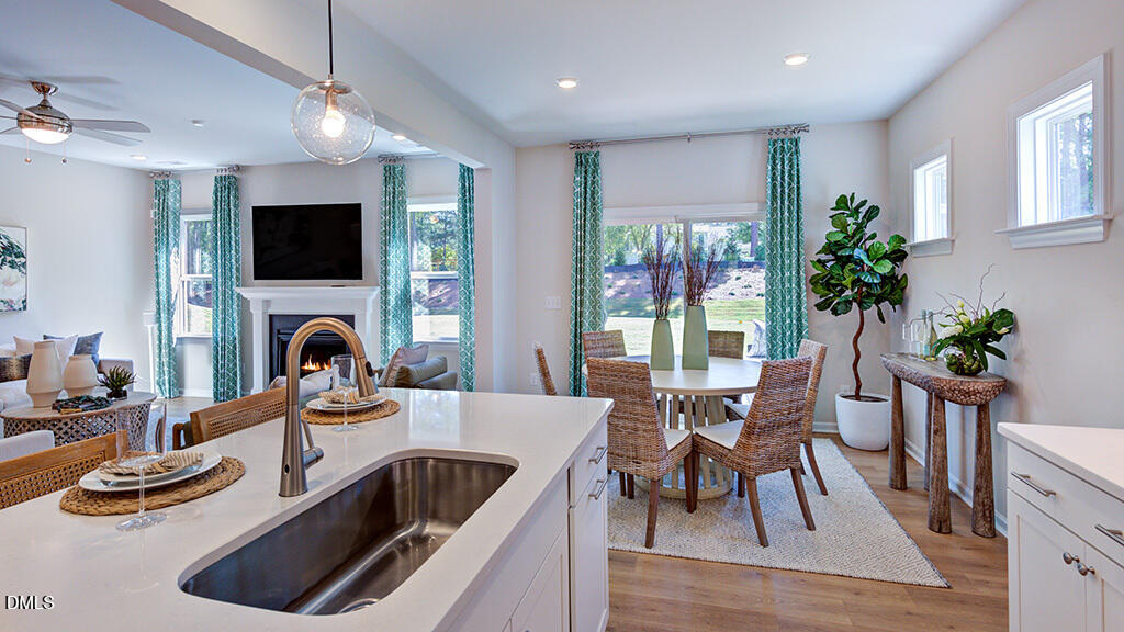 151 Rivulet Court Cary, NC 27519 - Photo 19 of 37 a kitchen with a stove a sink and a dining table with chairs