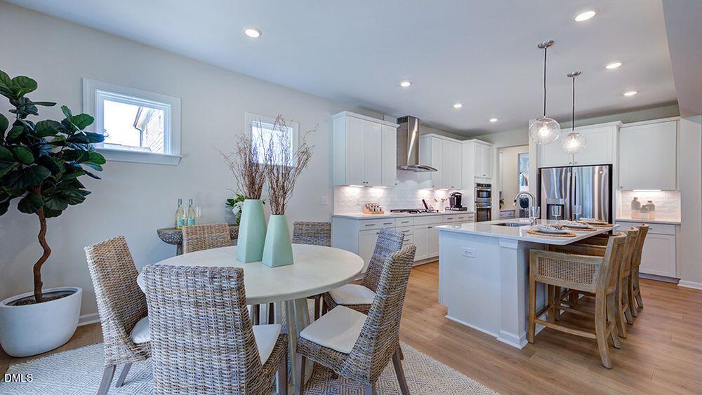 151 Rivulet Court Cary, NC 27519 - Photo 21 of 37 a dining room with furniture potted plants and wooden floor