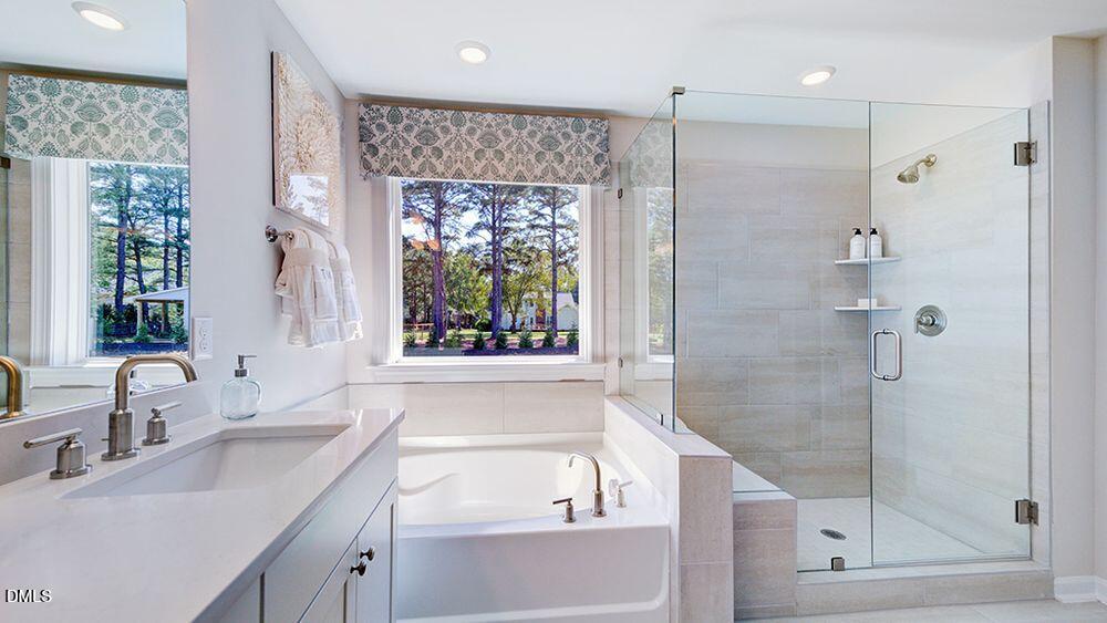 151 Rivulet Court Cary, NC 27519 - Photo 30 of 37 a bathroom with a shower sink and mirror with bathtub