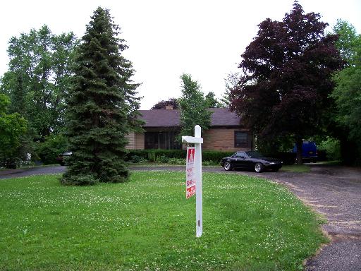 a front view of a house with a yard and tree