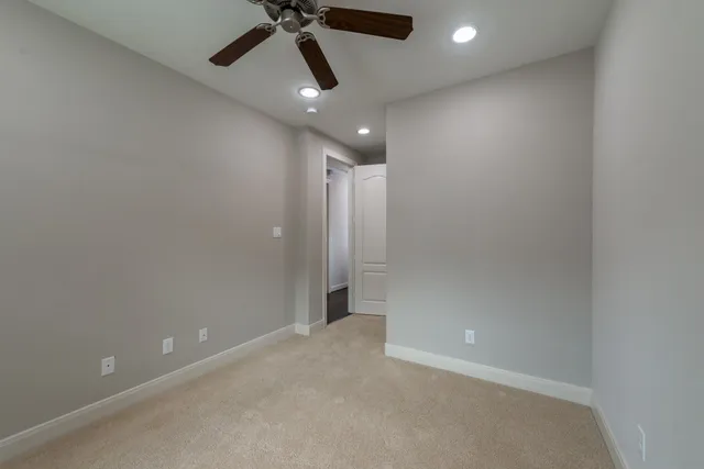 an empty room with a ceiling fan and a window