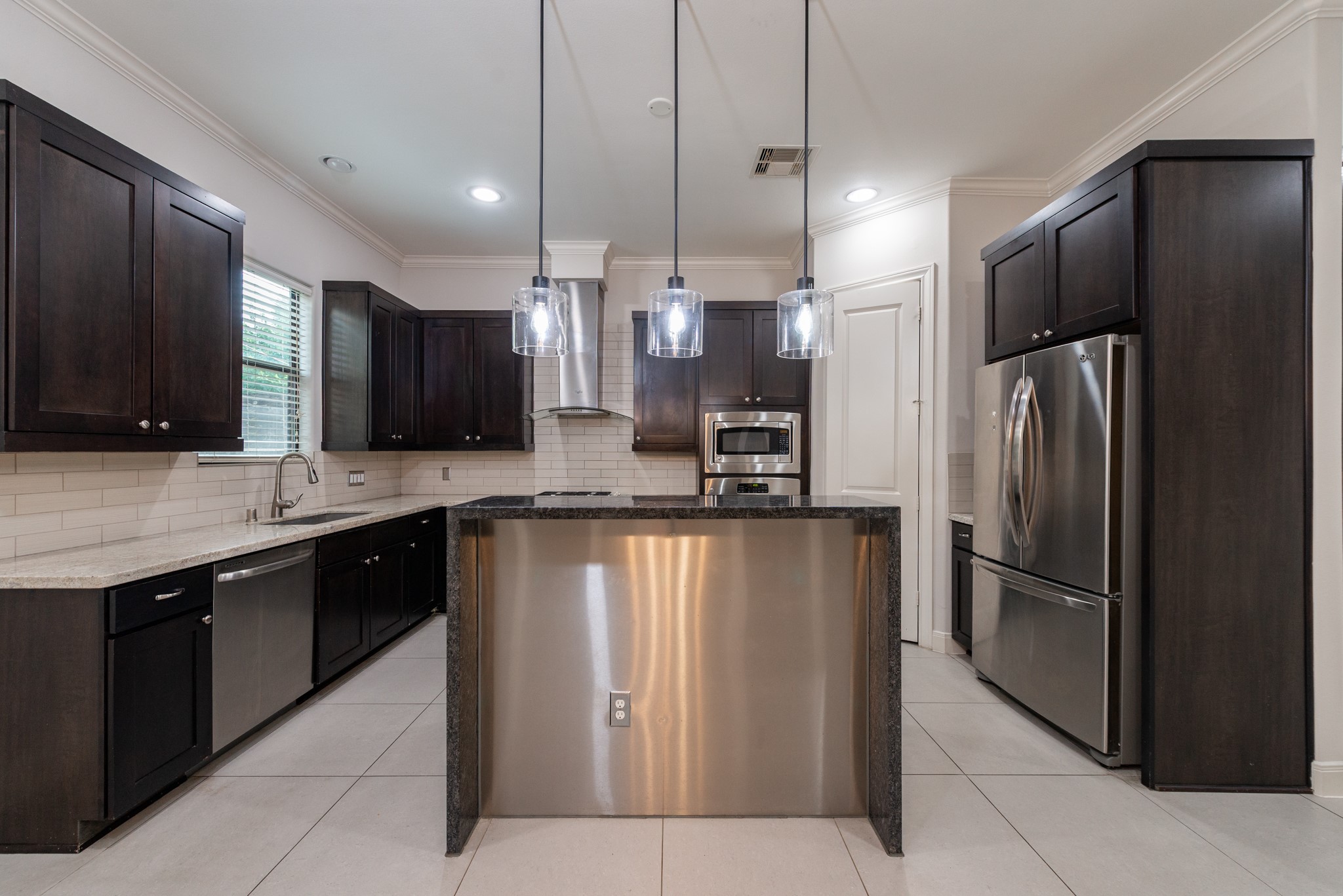 3504 Chenevert Street, Unit A Houston, TX 77004 - Photo 5 of 33 a large kitchen with stainless steel appliances kitchen island granite countertop a refrigerator and a sink