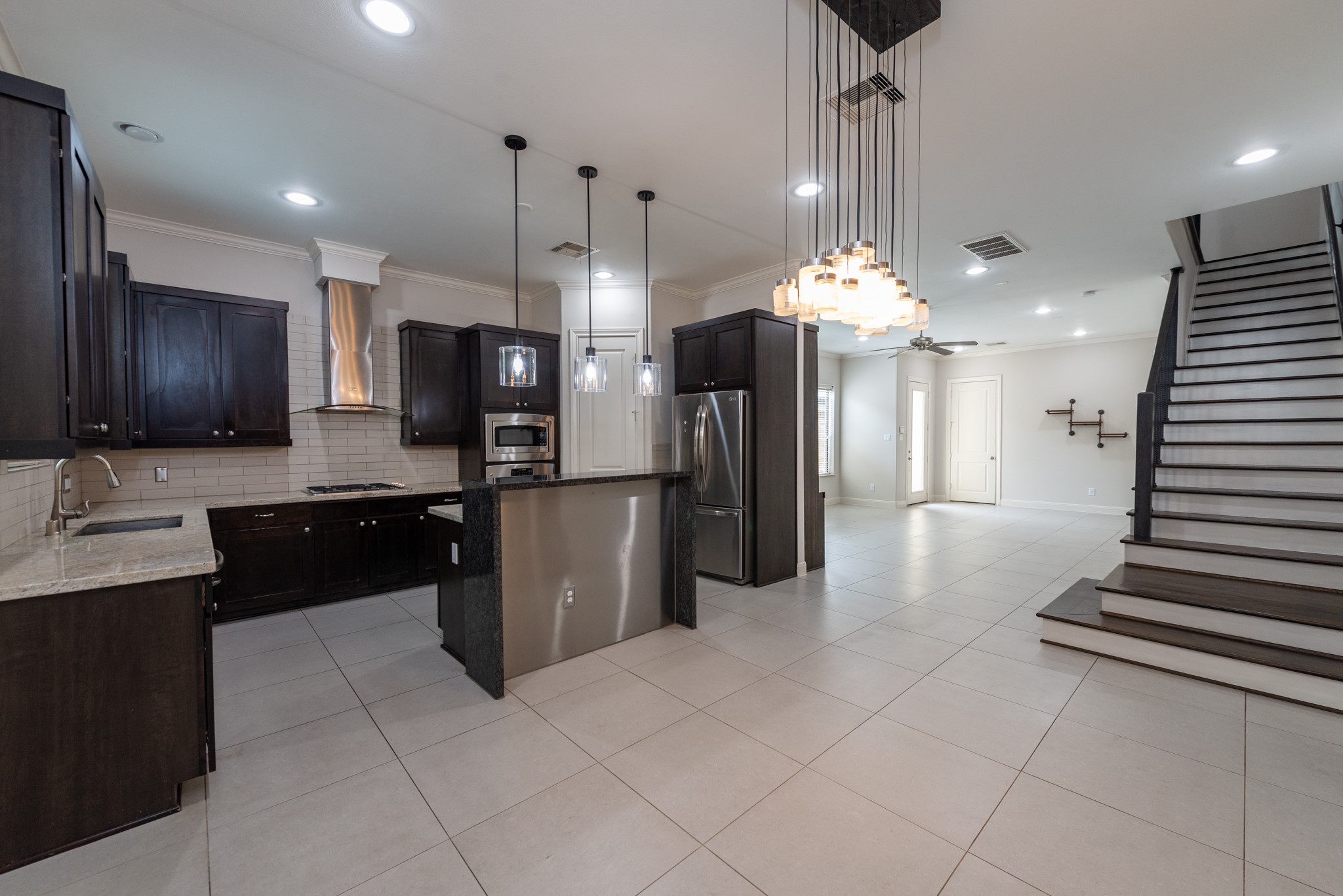 3504 Chenevert Street, Unit A Houston, TX 77004 - Photo 10 of 33 a kitchen with stainless steel appliances kitchen island granite countertop a refrigerator a stove a sink and a microwave