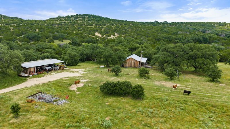 8400 Ranch Road 1431 Marble Falls, TX 78654 - Photo 21 of 30 Discover a tranquil rural retreat featuring a classic barn and an expansive, tree-dotted landscape.