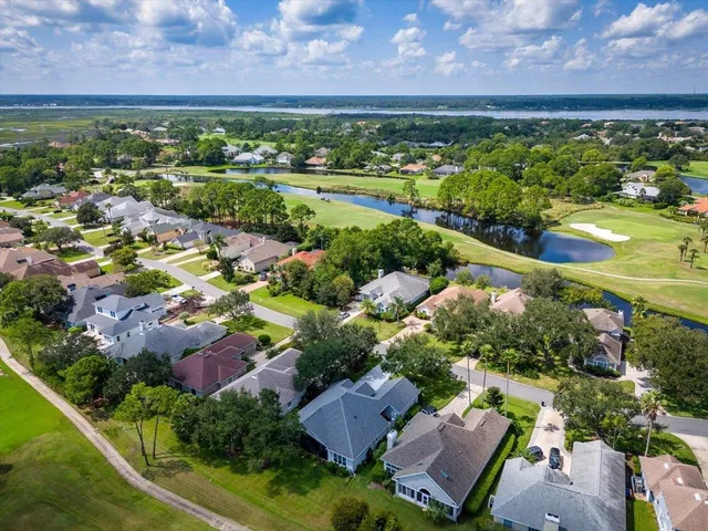 an aerial view of residential houses with outdoor space and a lake view