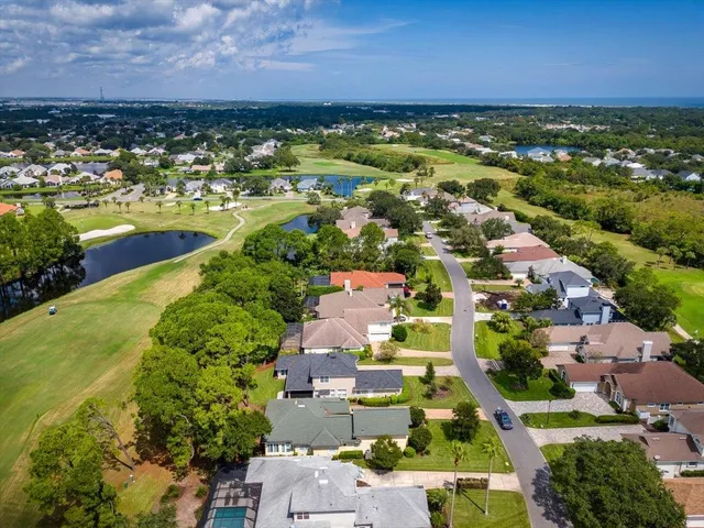 an aerial view of residential houses with outdoor space and ocean view