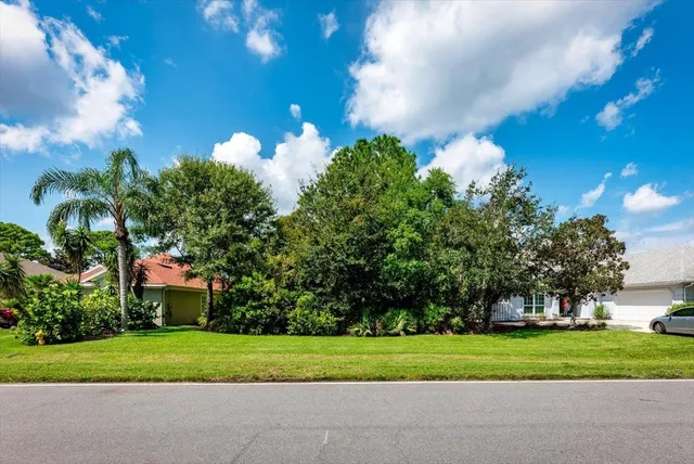 a front view of a house with a yard and trees