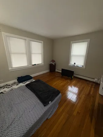 a bed sitting in a bedroom next to a window