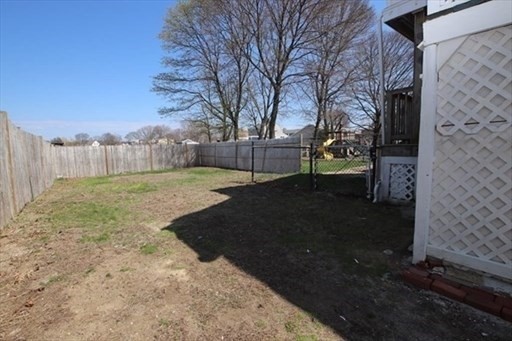 38 Ballard Street, Unit 2 Saugus, MA 01906 - Photo 17 of 17 a view of a backyard with large trees and wooden fence