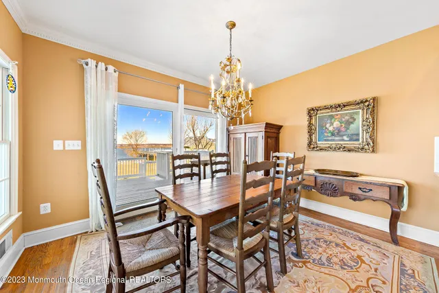 a dining room with furniture a chandelier and wooden floor