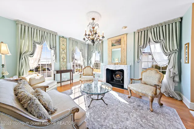 a living room with furniture a fireplace and a chandelier