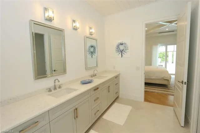 a en suite bathroom with a double vanity sink and a mirror