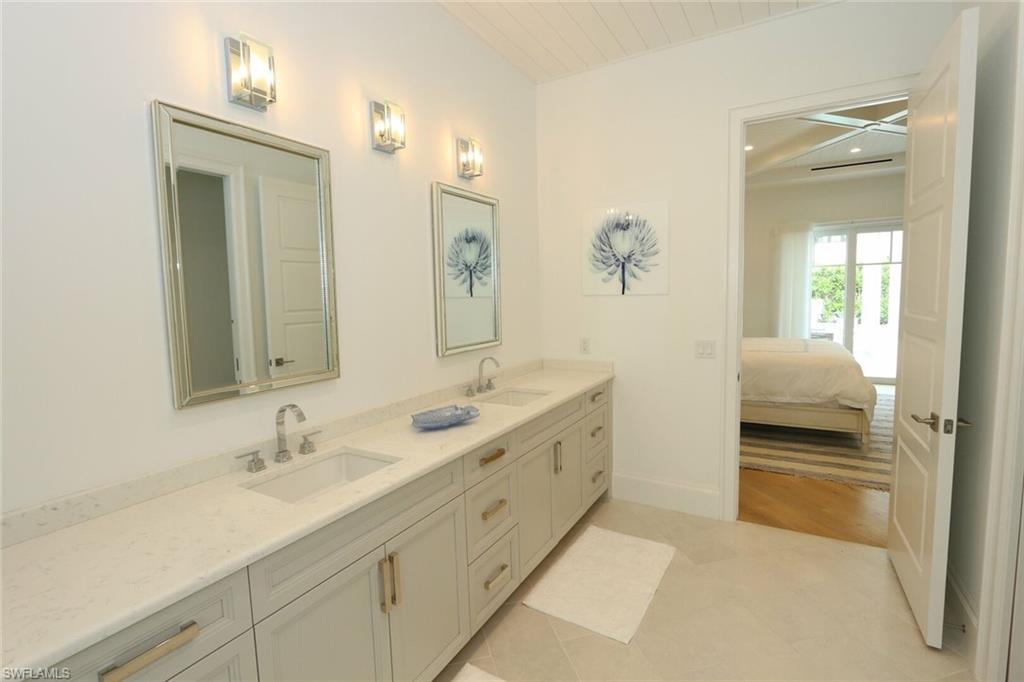 300 2nd Avenue North Naples, FL 34102 - Photo 17 of 41 a en suite bathroom with a double vanity sink and a mirror