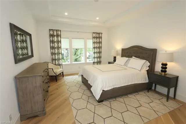 a spacious bedroom with a bed and a lamp on table