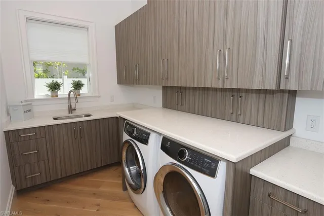 a utility room with sink dryer and washer