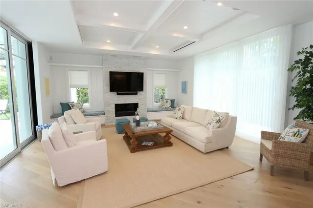 a living room with furniture a flat screen tv and a large window