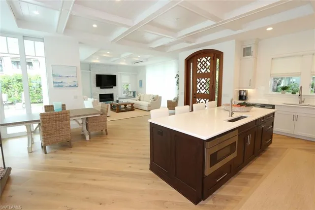 a living room with stainless steel appliances kitchen island granite countertop a stove and a view of living room