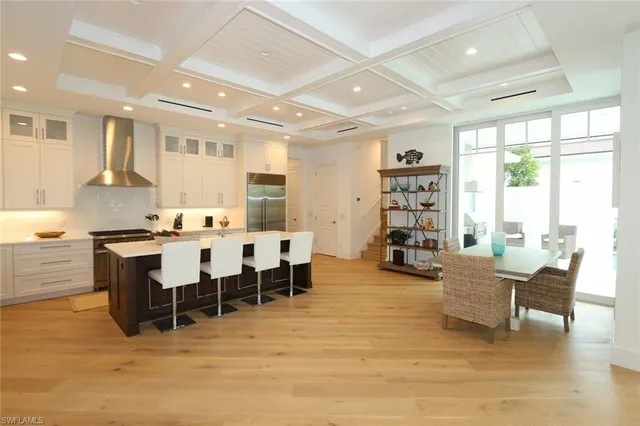 a living room with furniture a dining table and a large window