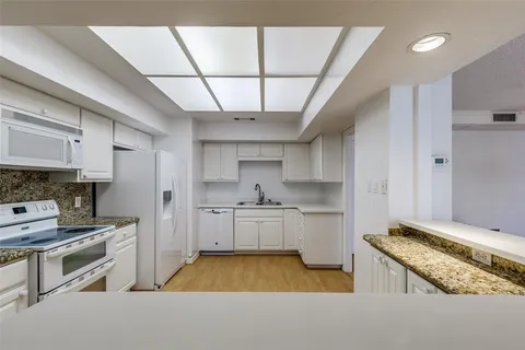 a kitchen with stainless steel appliances granite countertop a sink a stove and a refrigerator