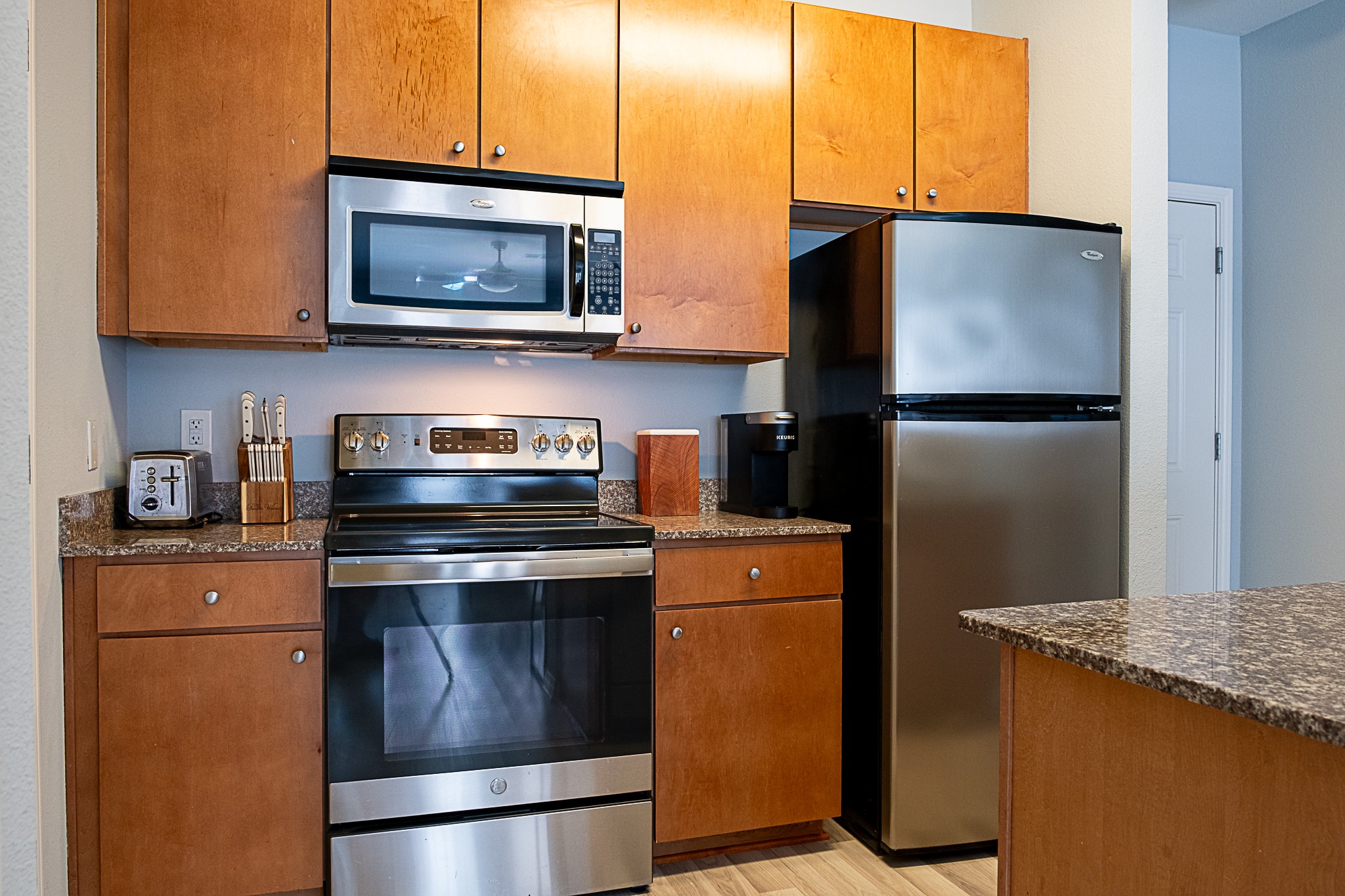 2502 Leon Street, Unit 309 Austin, TX 78705 - Photo 6 of 19 a kitchen with stainless steel appliances granite countertop a refrigerator stove and microwave