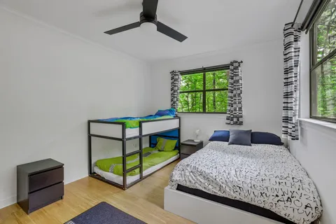 a bedroom with a bed and a dresser next to a window