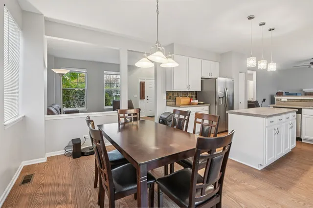 a kitchen with a dining table chairs stainless steel appliances and cabinets
