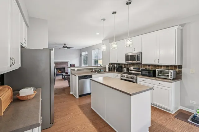 a kitchen with white cabinets and stainless steel appliances