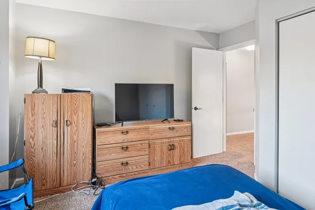 a bedroom with a bed and a wooden floor