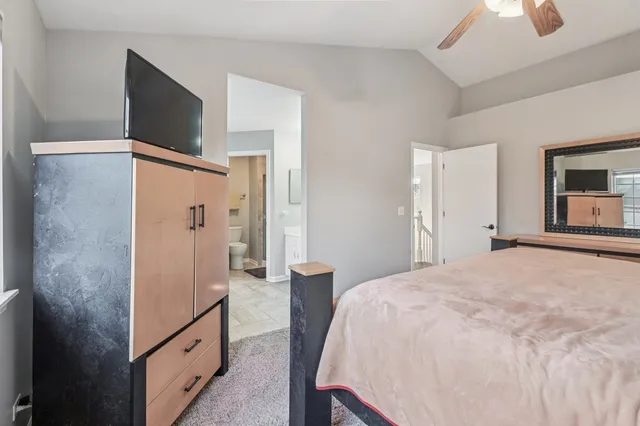 a spacious bedroom with a bed and a flat screen tv