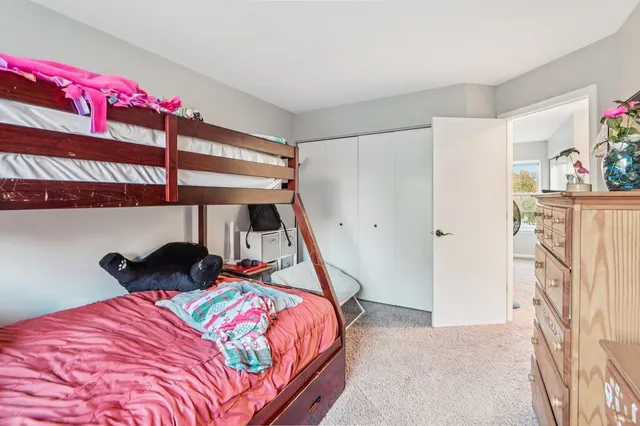 a bedroom with a bed closet and a window