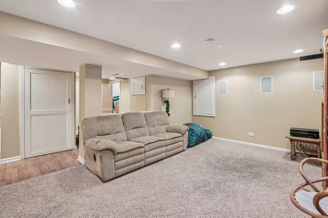 a living room with furniture a table and a refrigerator