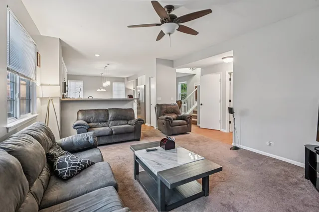 a living room with furniture a fireplace and a chandelier