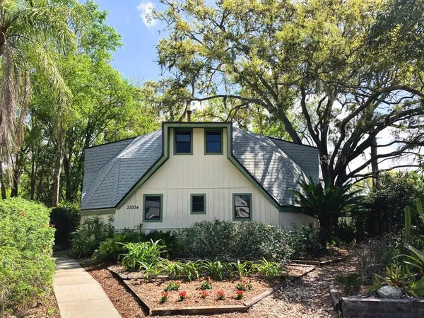 a front view of a house with a yard and potted plants