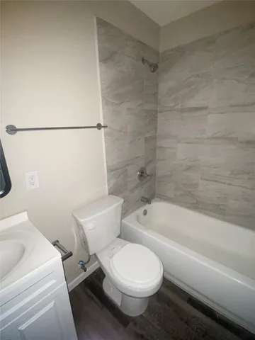a white toilet and tub sitting next to a bathroom sink