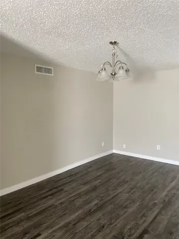 a view of a room with wooden floor and ceiling fan