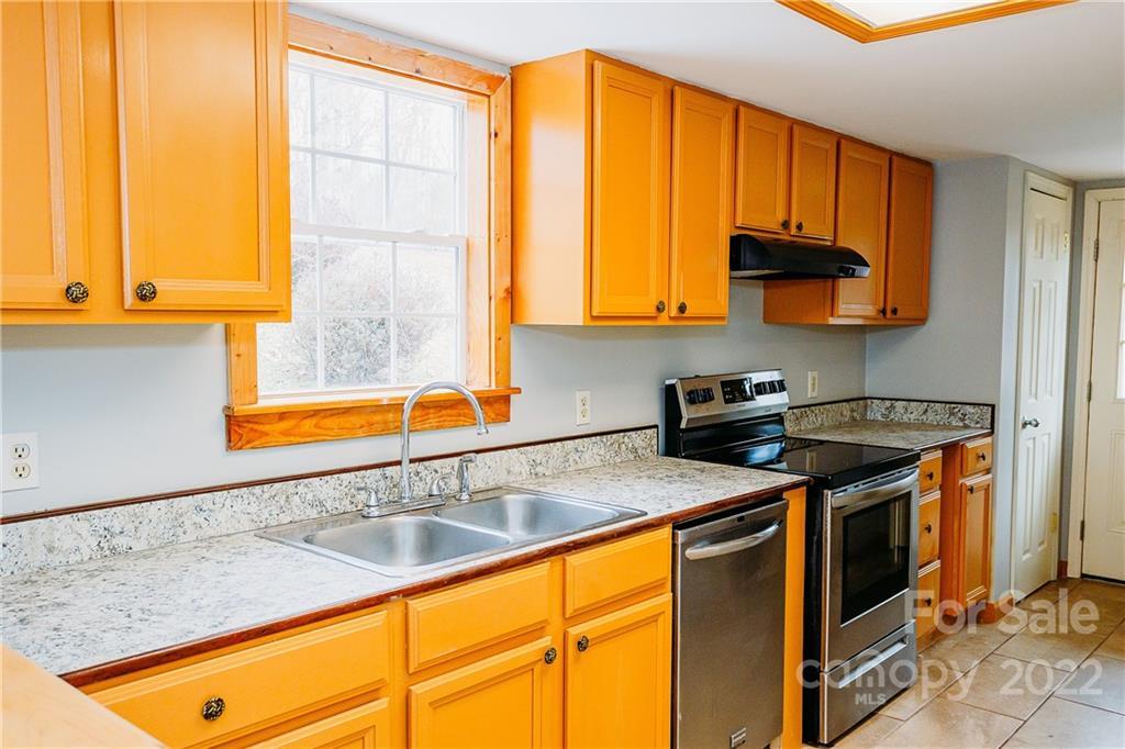 300 Boyd Road Leicester, NC 28748 - Photo 4 of 46 a kitchen with stainless steel appliances granite countertop a sink a stove and a microwave