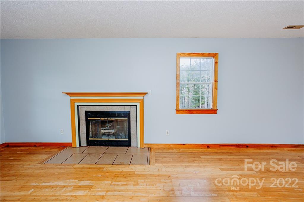 300 Boyd Road Leicester, NC 28748 - Photo 8 of 46 a view of an empty room with a fireplace and a window
