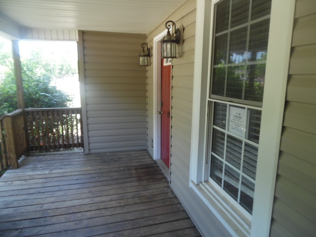 19 Haynes Street Due West, SC 29639 - Photo 6 of 8 A welcoming front porch features weathered wooden floors and inviting sconce lighting.