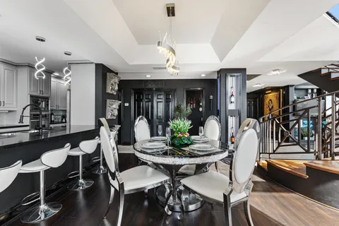 a kitchen with a dining table chairs and a chandelier
