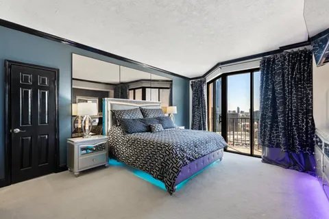 a bedroom with a bed and a view of living room